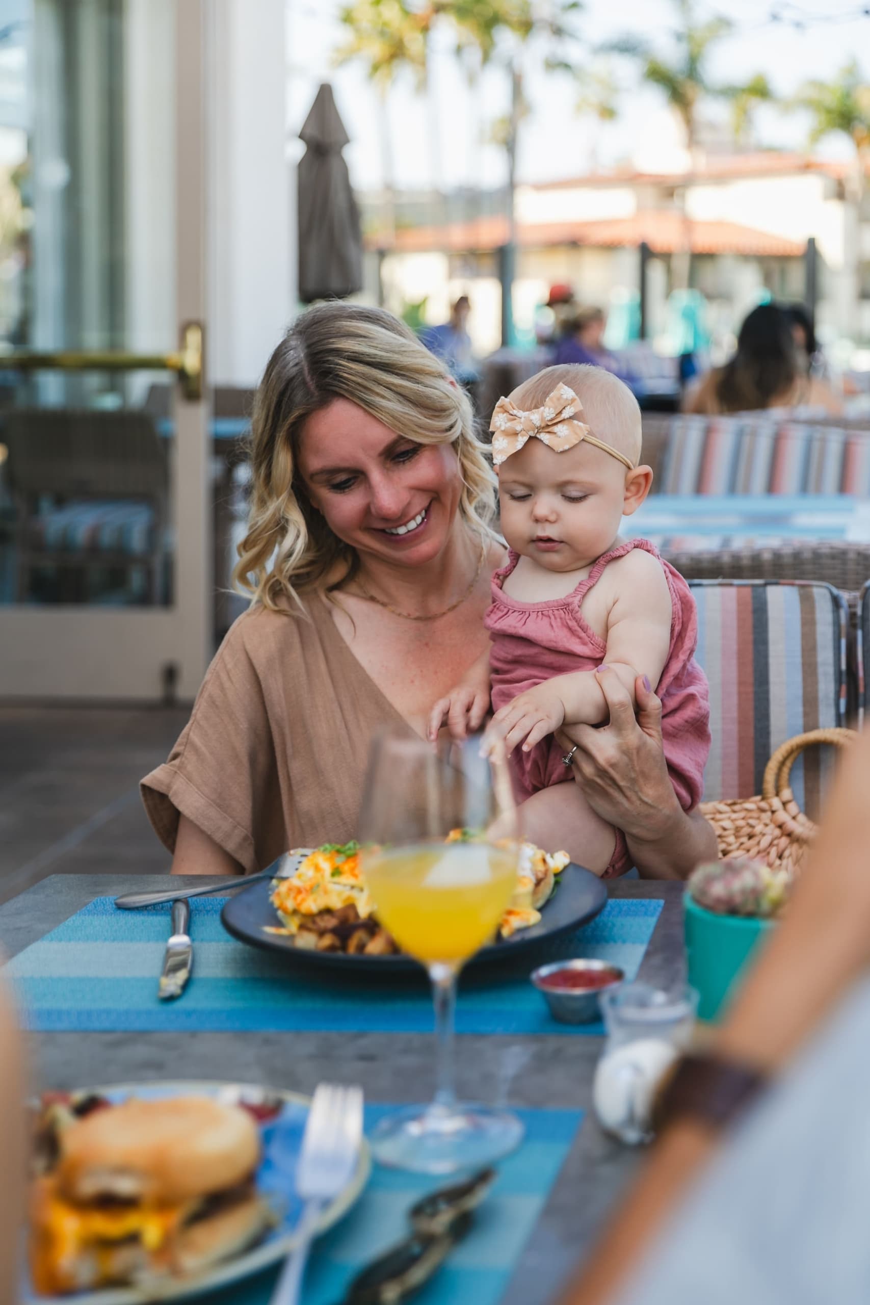 A mother on Mothers Day with her baby in hand while eating brunch