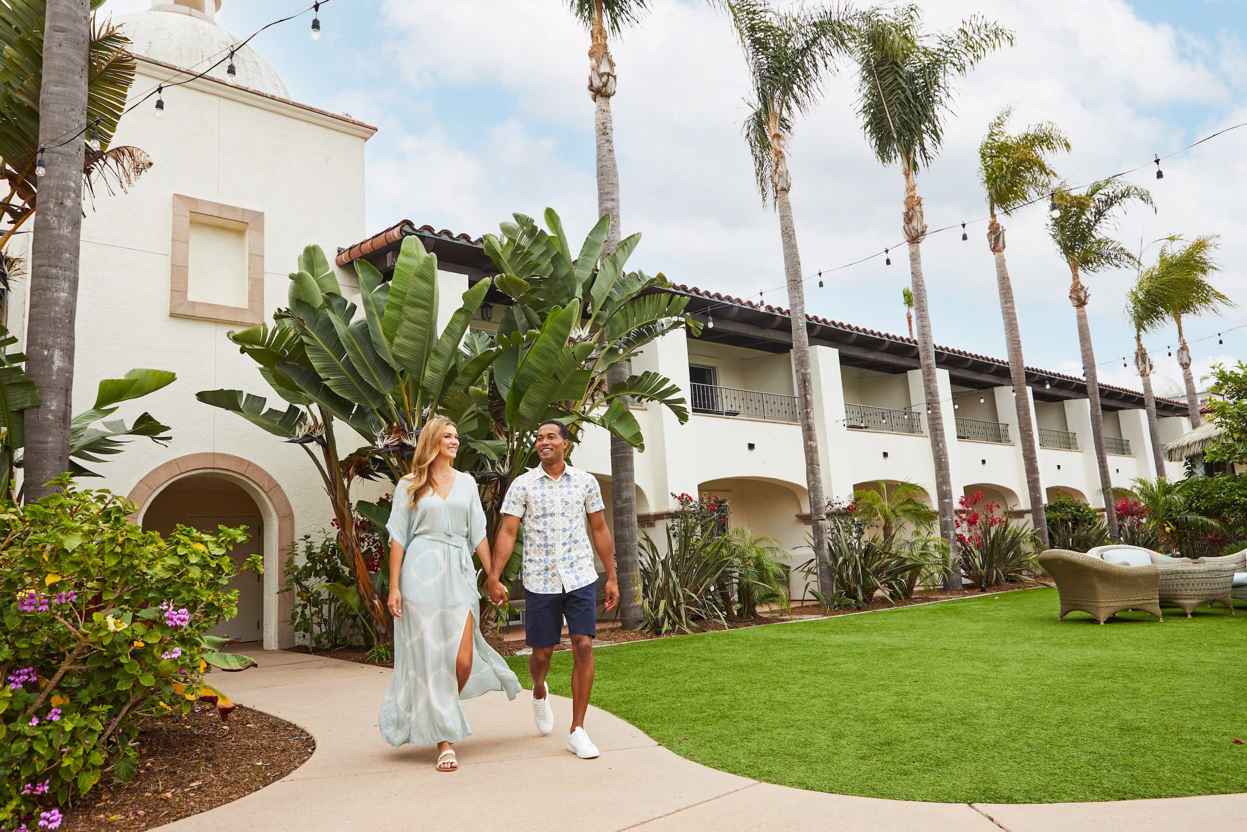 A couple walking in Kona Kai court yard holding hands