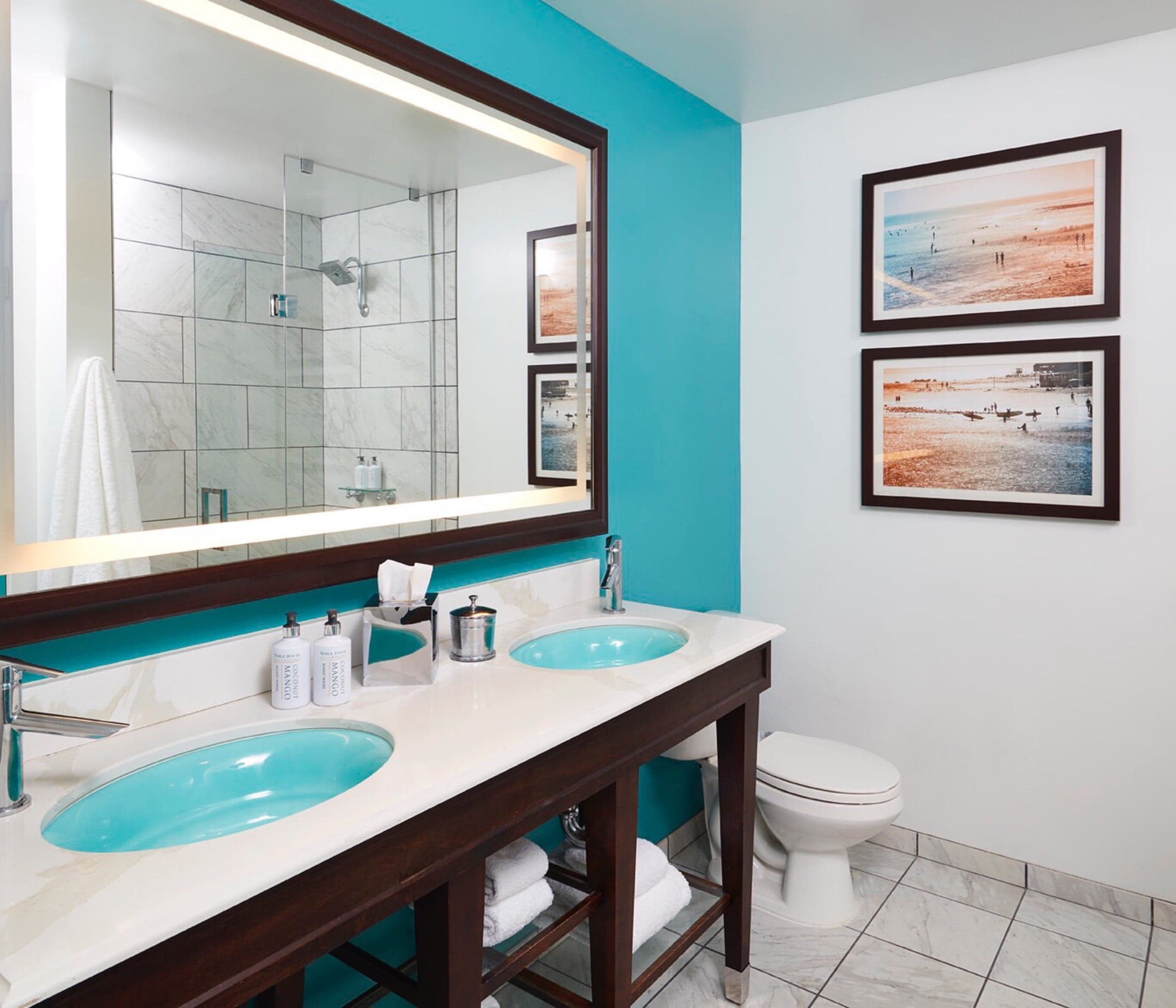 A bathroom with a double sink vanity and a large mirror in a room at Kona Kai