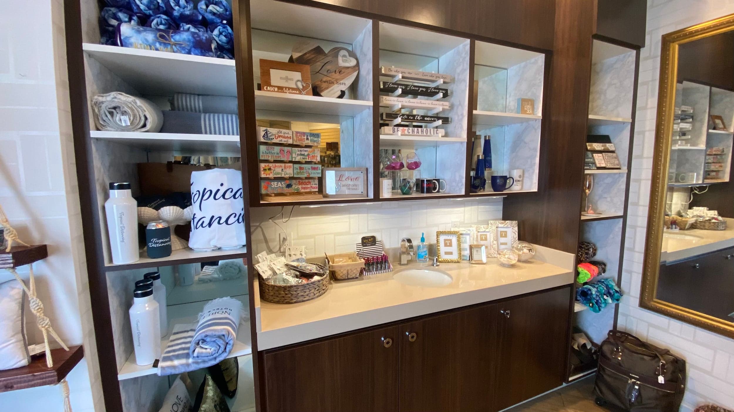 A bathroom vanity with shelves of towels and accessories