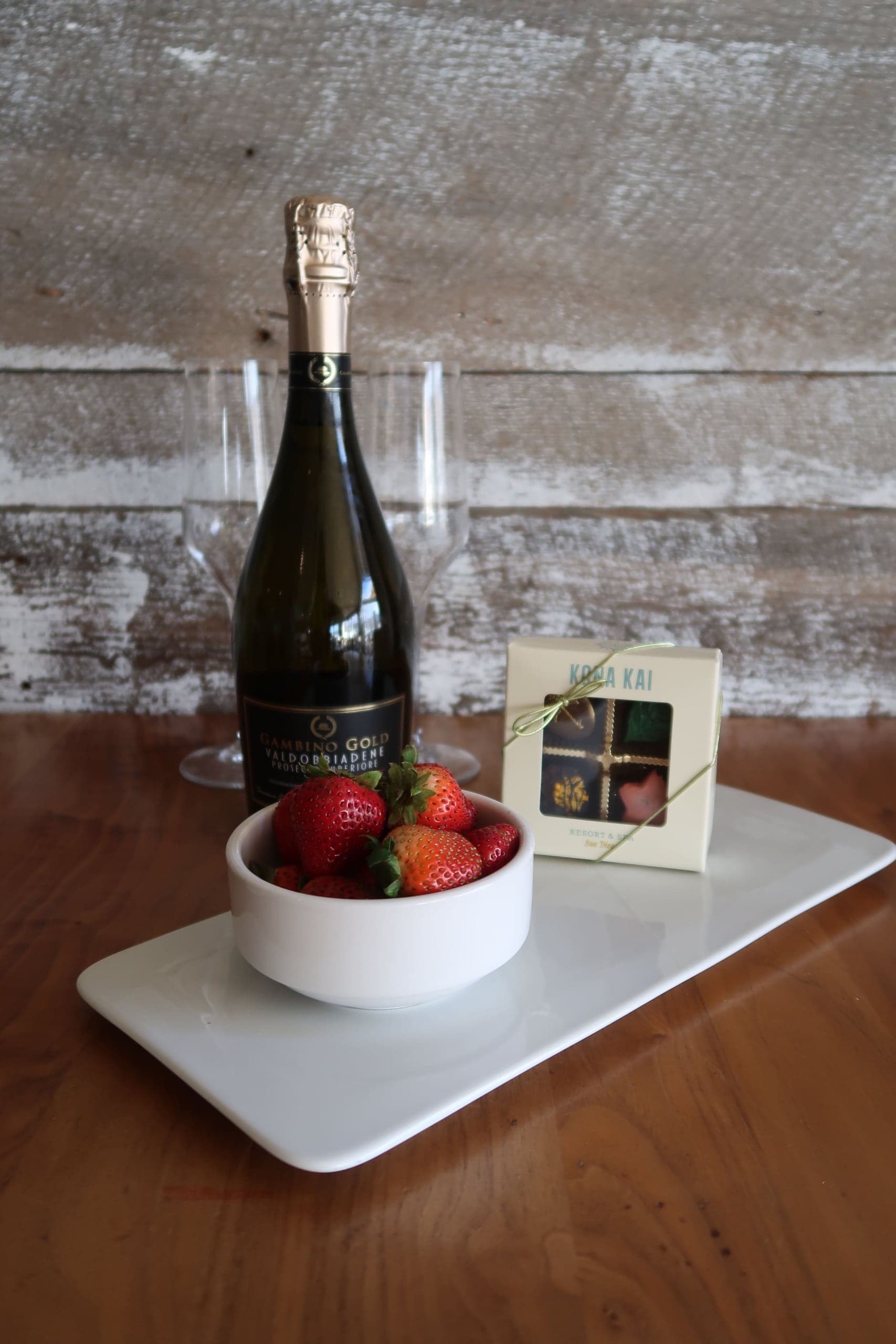 A plate strawberries and chocolates with some wine