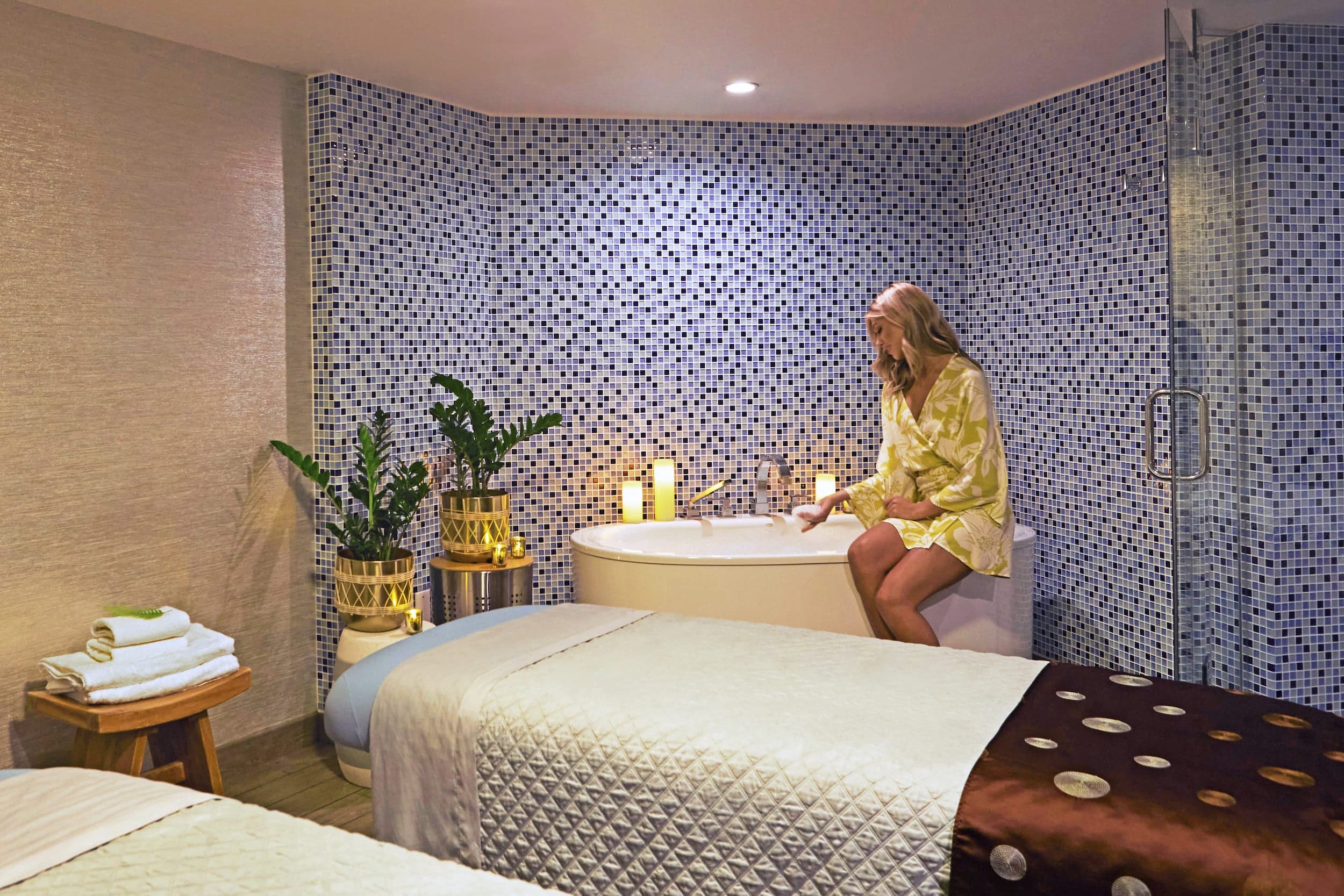 A woman sitting on the edge of a soaker tub in the spa