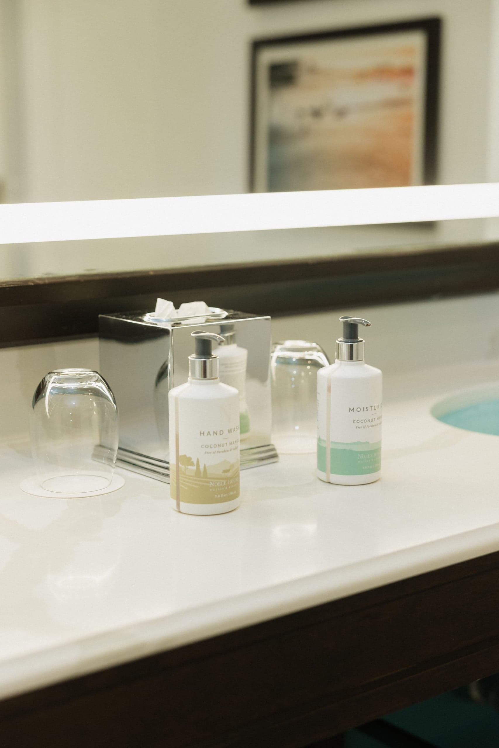 The bathroom vanity with hand sop and drinking cups in a room at Kona Kai