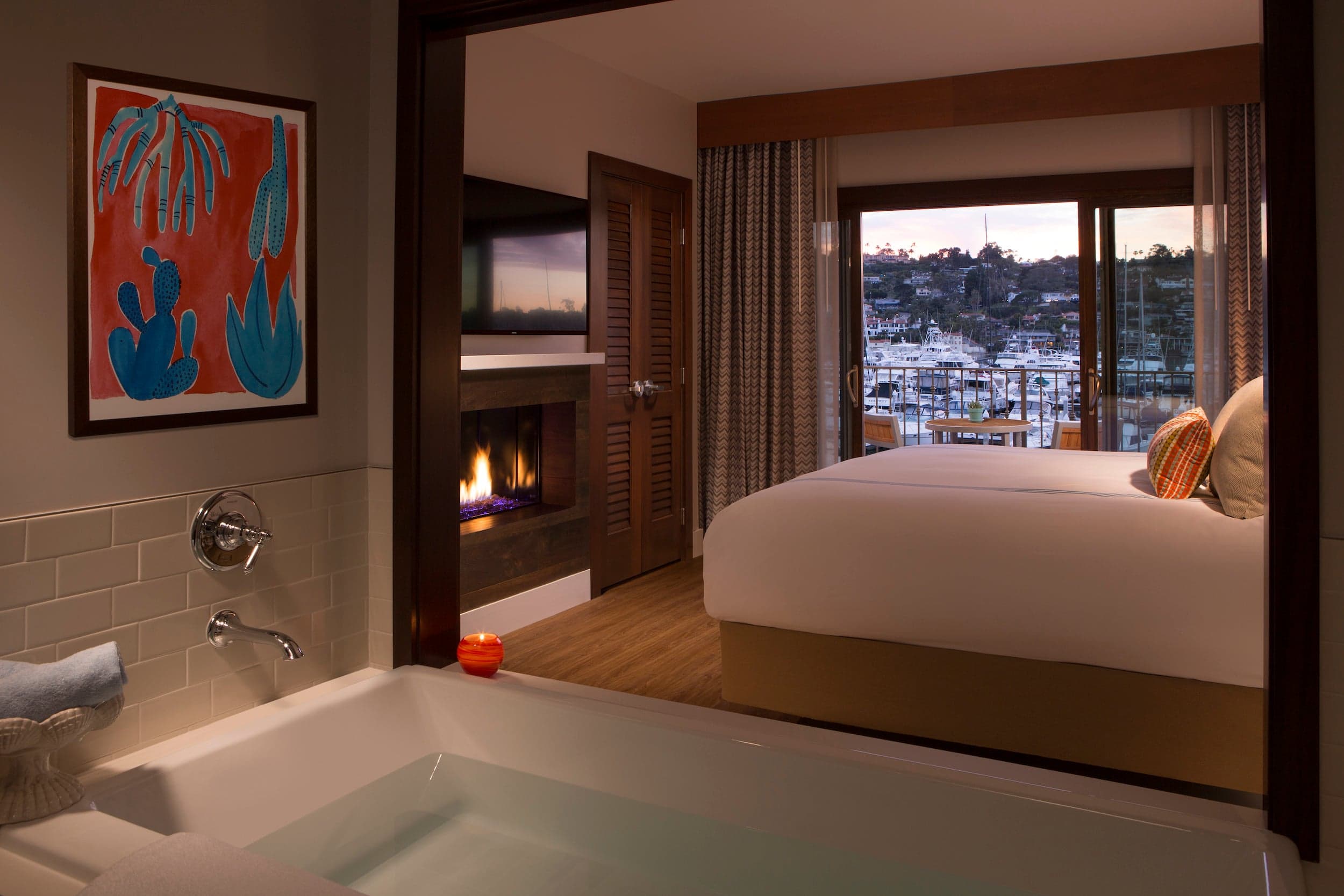 A one bedroom suite with a gas fireplace and a room view of the marina at Kona Kai