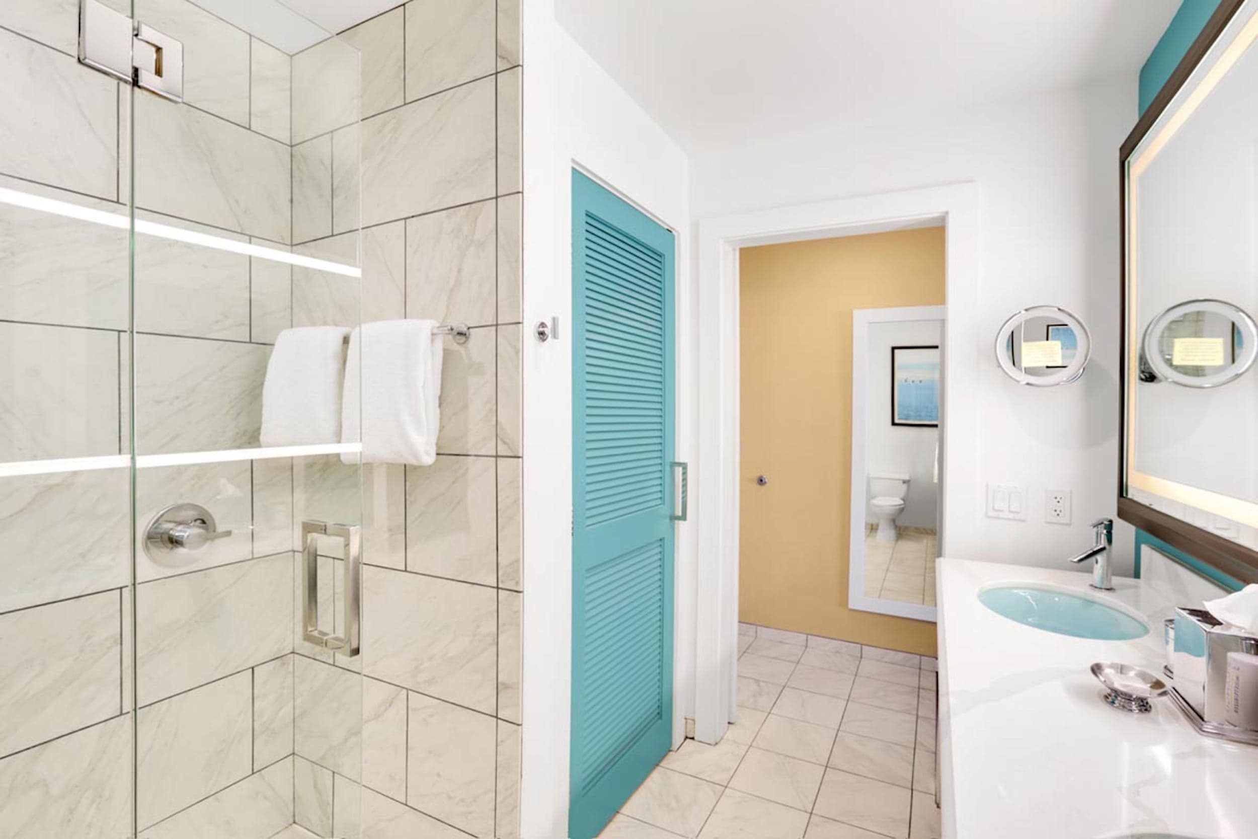 A bright washroom with a double sink vanity and large walk-in shower at Kona Kai