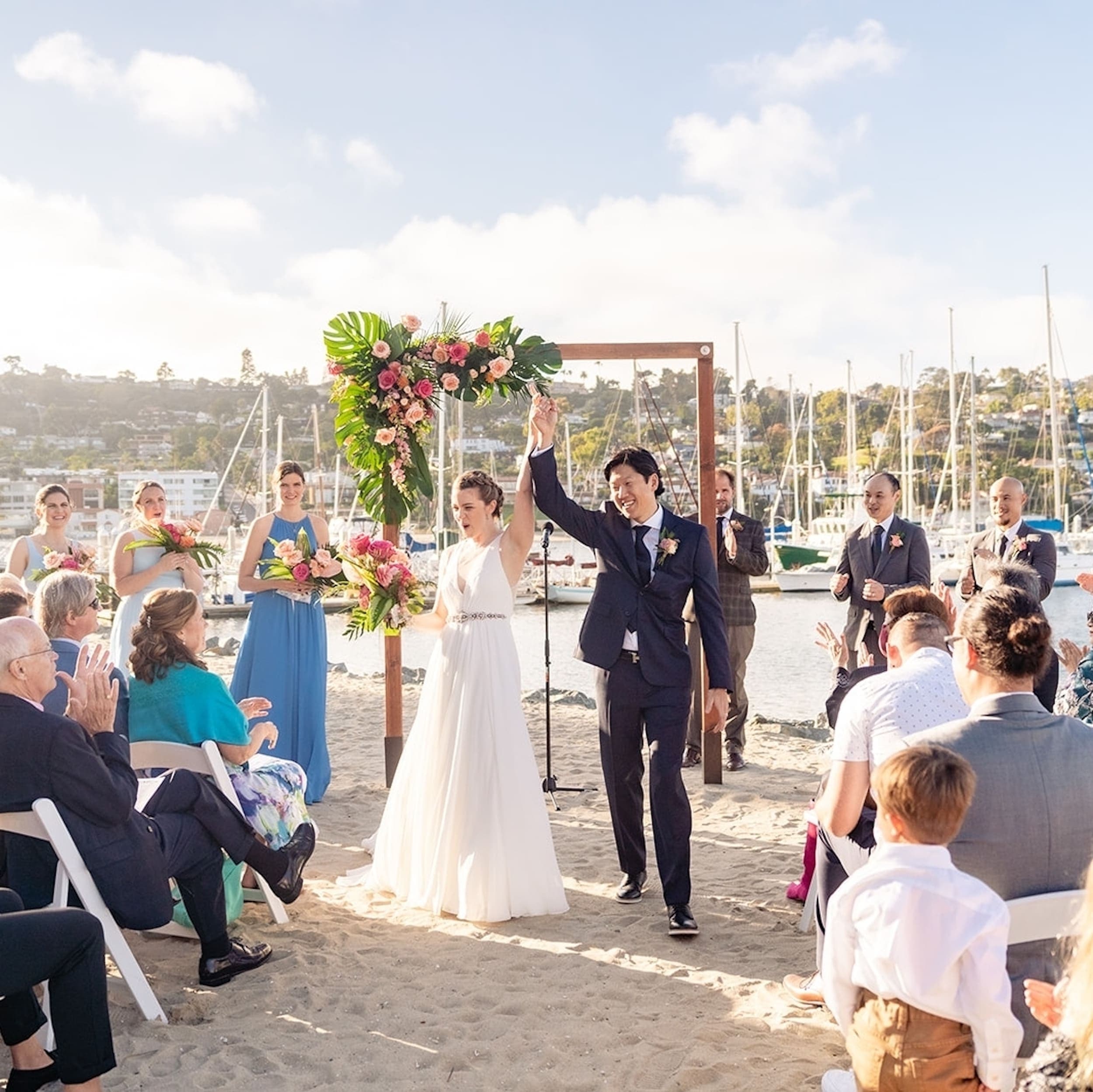 A newly wed couple walking up the isle holding hands in the air
