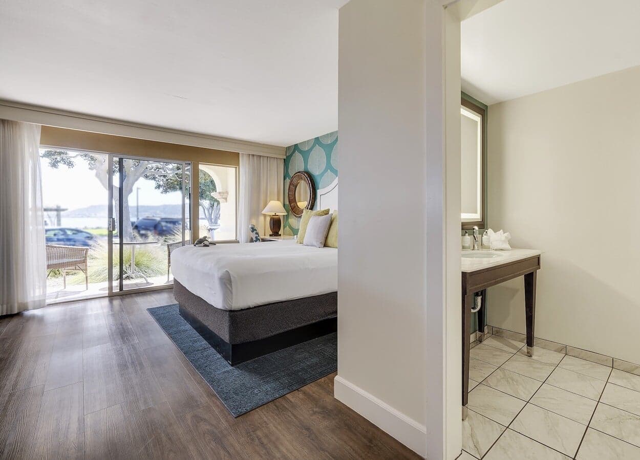 A large ADA room with a king bed, access to a ground level patio and a large washroom at Kona Kai