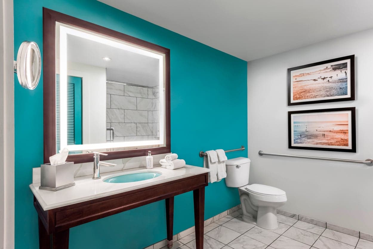 An ADA bathroom at Kona Kai with wall bars and plenty of space for a wheelchair