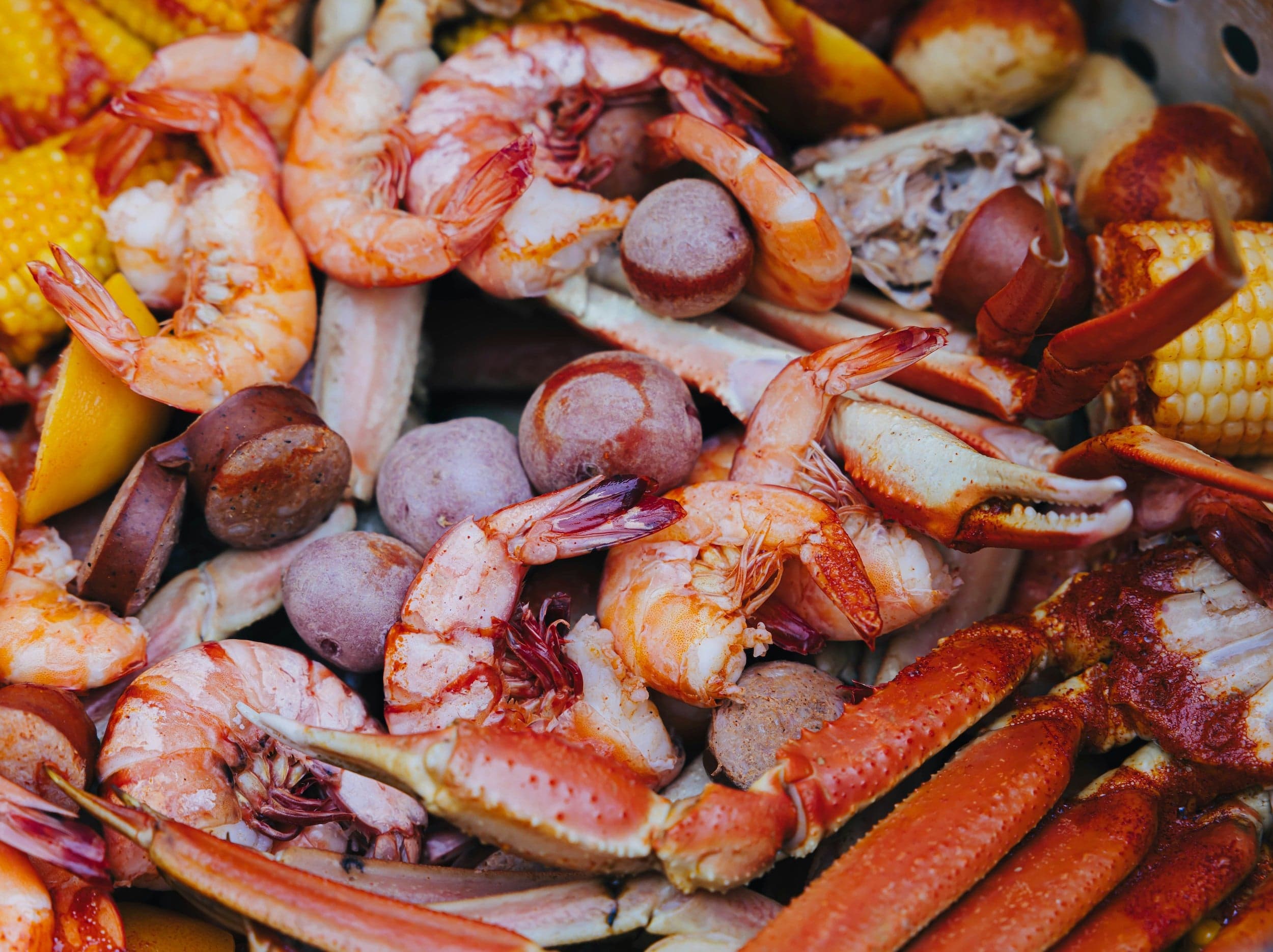 Seafood, corn, sausage, and grapes for a clam bake