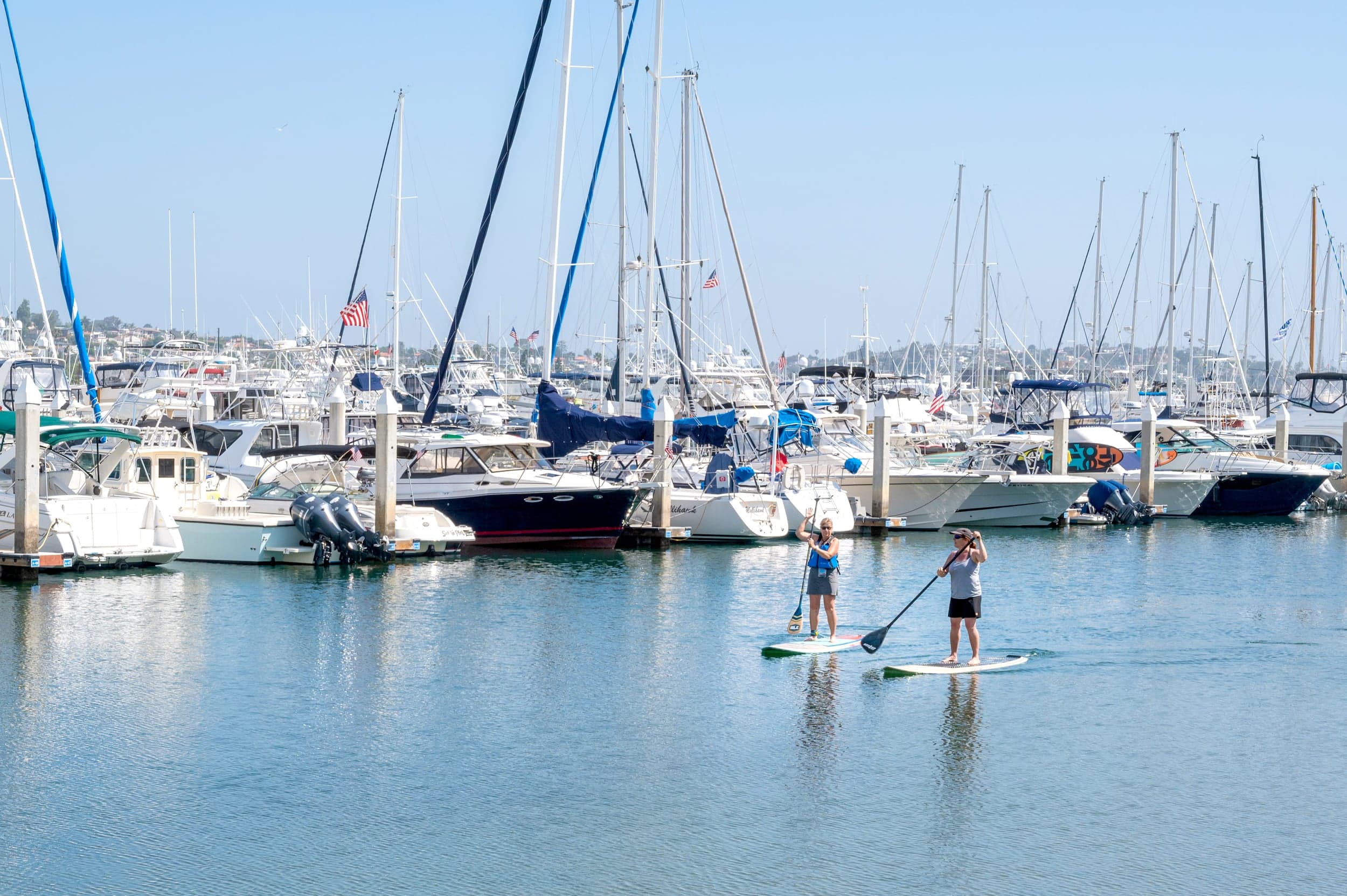 2 people paddle boarding out front of Kona Kai