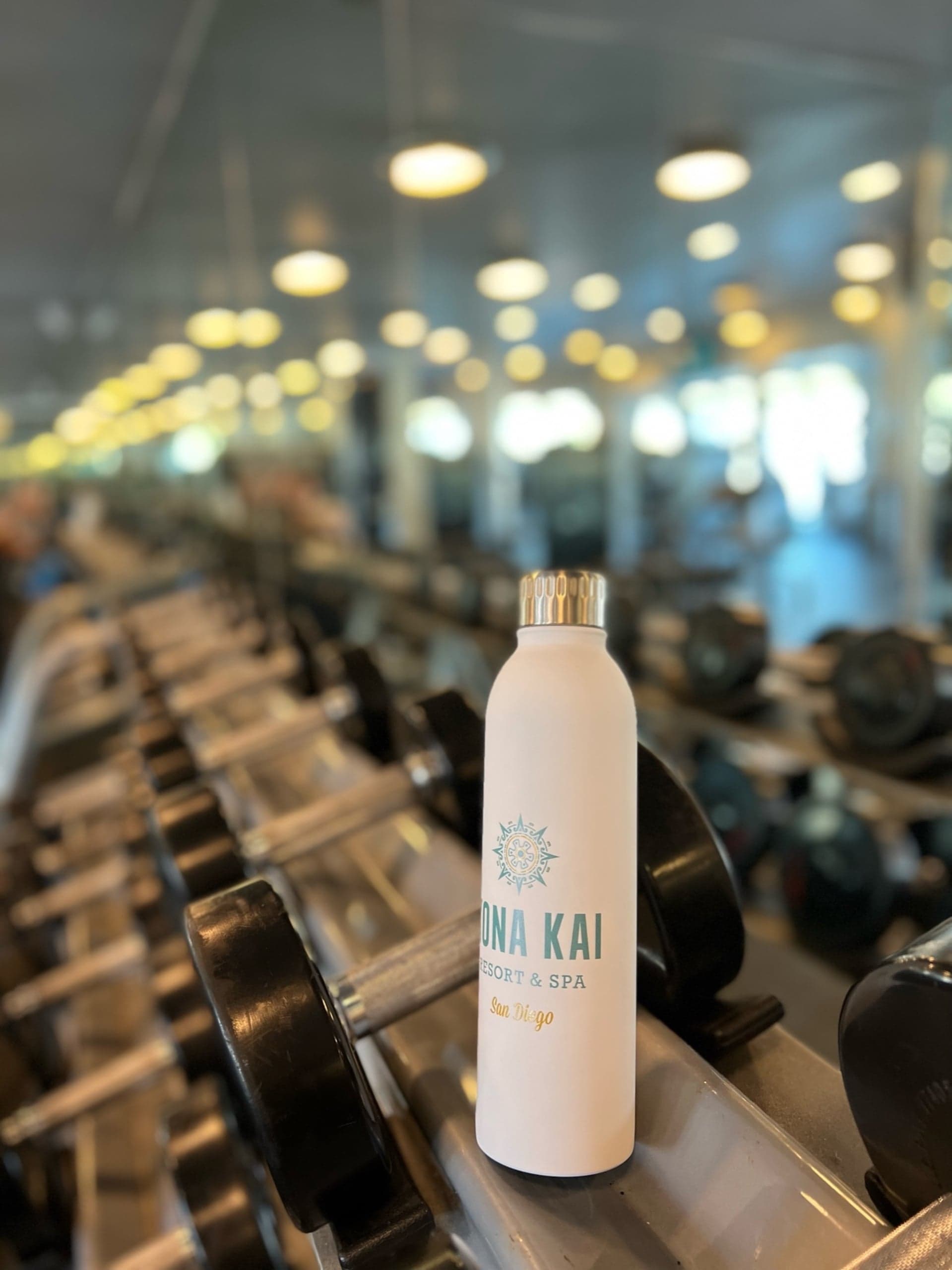 A Kona Kai water bottle amongst weights at the fitness centre