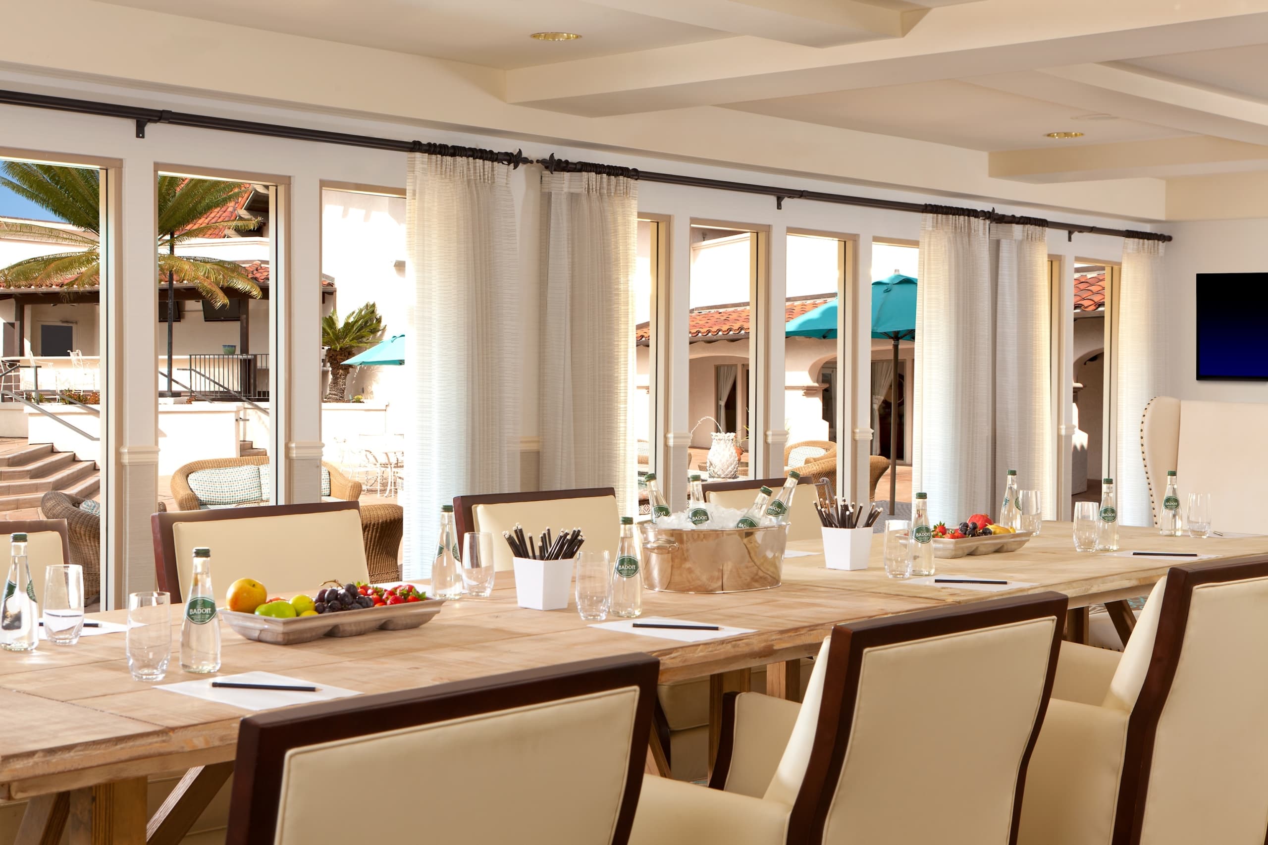The Coronado Meeting room at Kona Kai, A bright room with a conference table and bay windows looking out on a courtyard