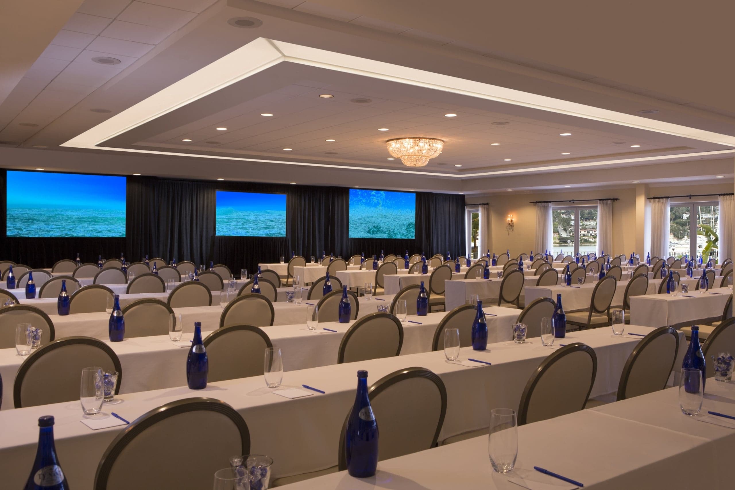 The Point Loma Ballroom set up for a conference, with rows of long tables and chairs pointed at screens