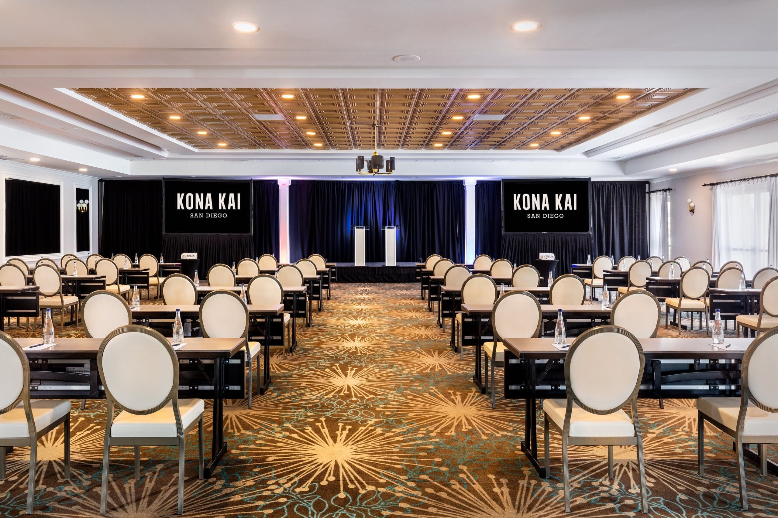 The Point Loma Ballroom set up for a conference, with rows of long tables and chairs pointed at a stage