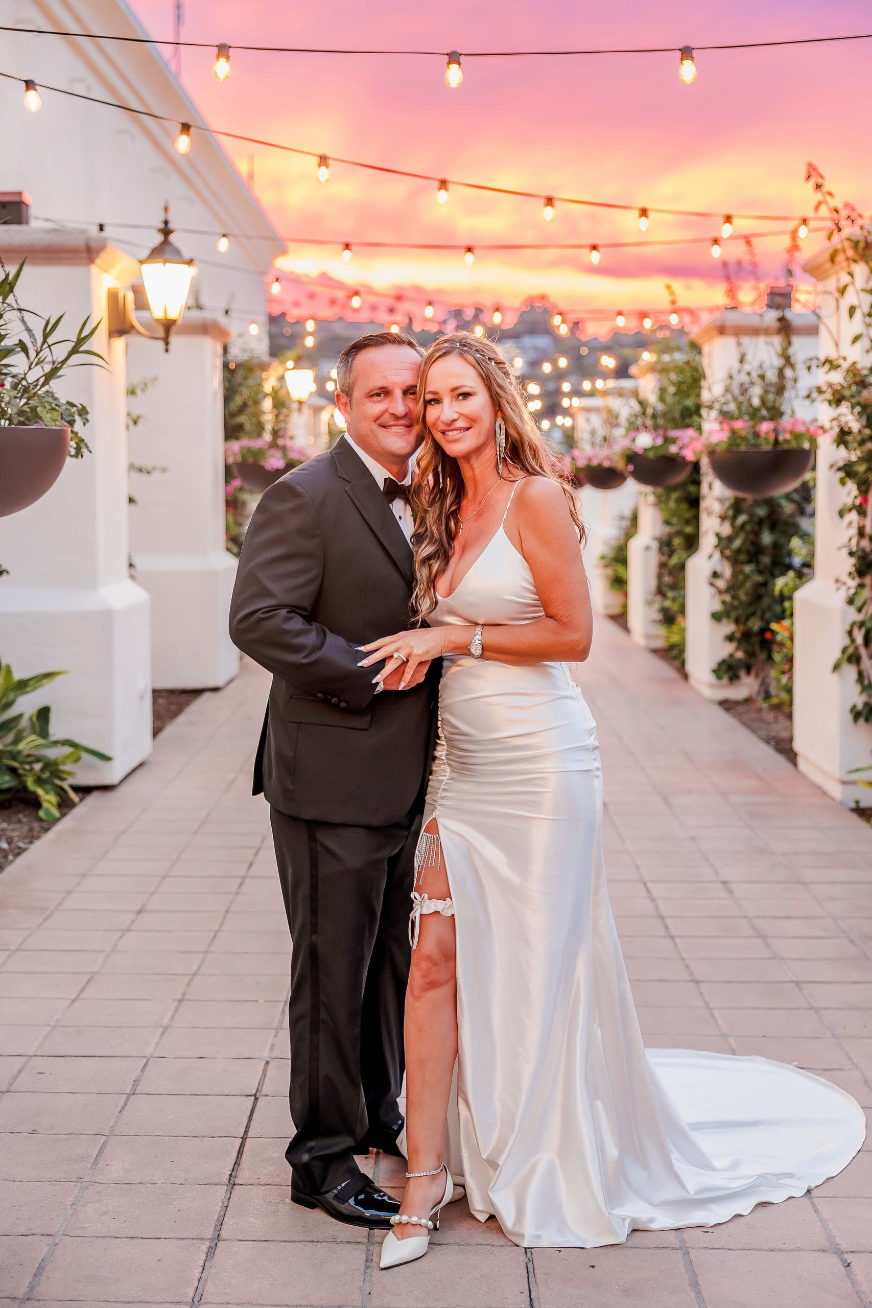 Romantic outdoor wedding portrait with bistro lights and Mediterranean architecture at Kona Kai Resort & Spa in San Diego