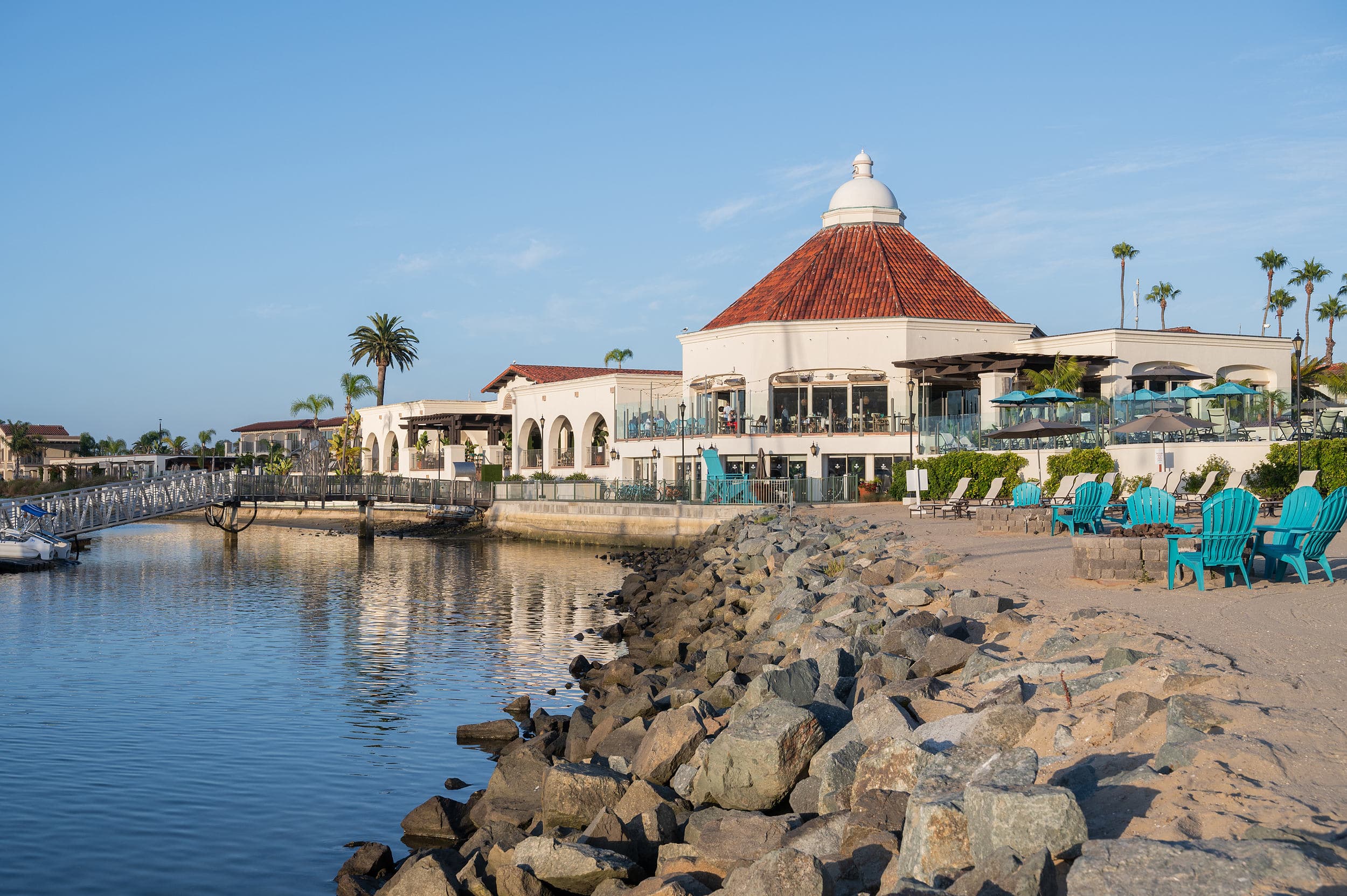Kona Kai Resort & Spa San Diego seen from the sandy beach on Shelter Island, with the domed Vessel Restaurant overlooking the marina