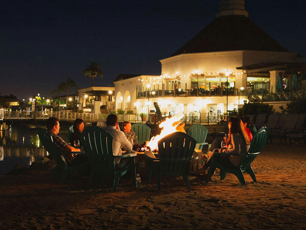 Family around bond fire on the beach at Kona Kai Resort