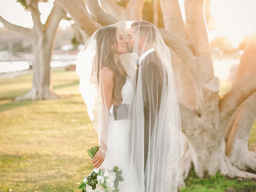 Wedding couple with veil over heads in San Diego