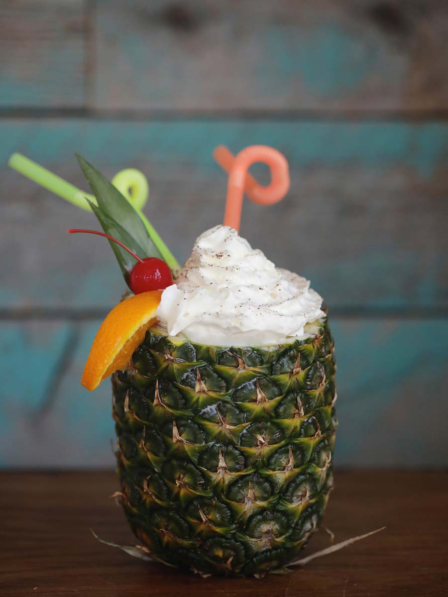 A drink in a pineapple.