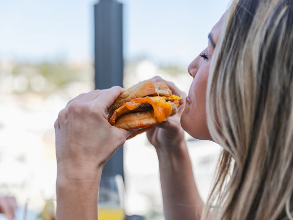 Lady Eating A Burger From Vessel Restaurant